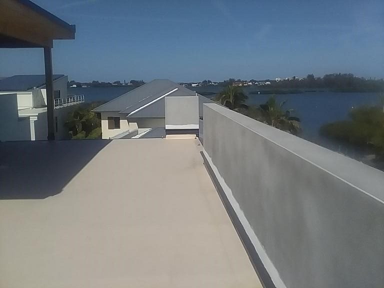 Walkable membrane roof deck with a parapet wall on a waterfront home