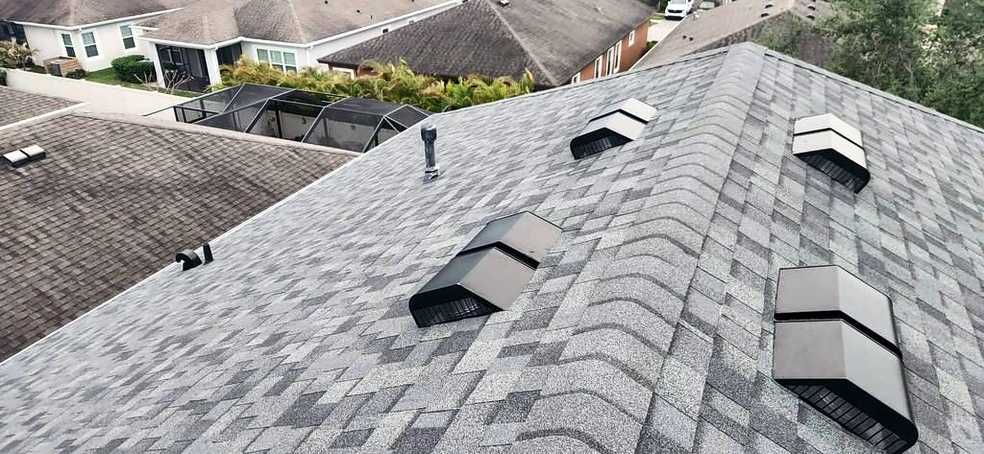 Gray architectural shingle roof with attic exhaust vents