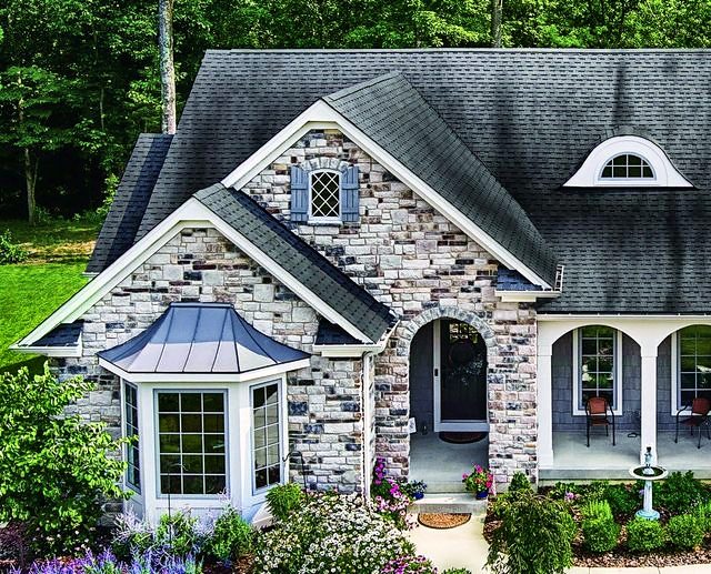Stone-front home with a dark gray architectural shingle roof