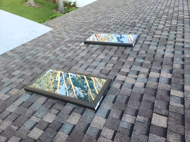 Multi-tone gray-brown shingle roof with two skylights