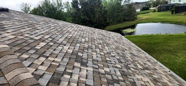 Sandy tan shingle roof overlooking a pond and lawn