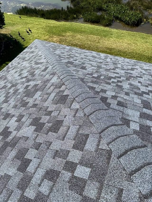 Blue-gray shingle roof ridge above a lakeside lawn
