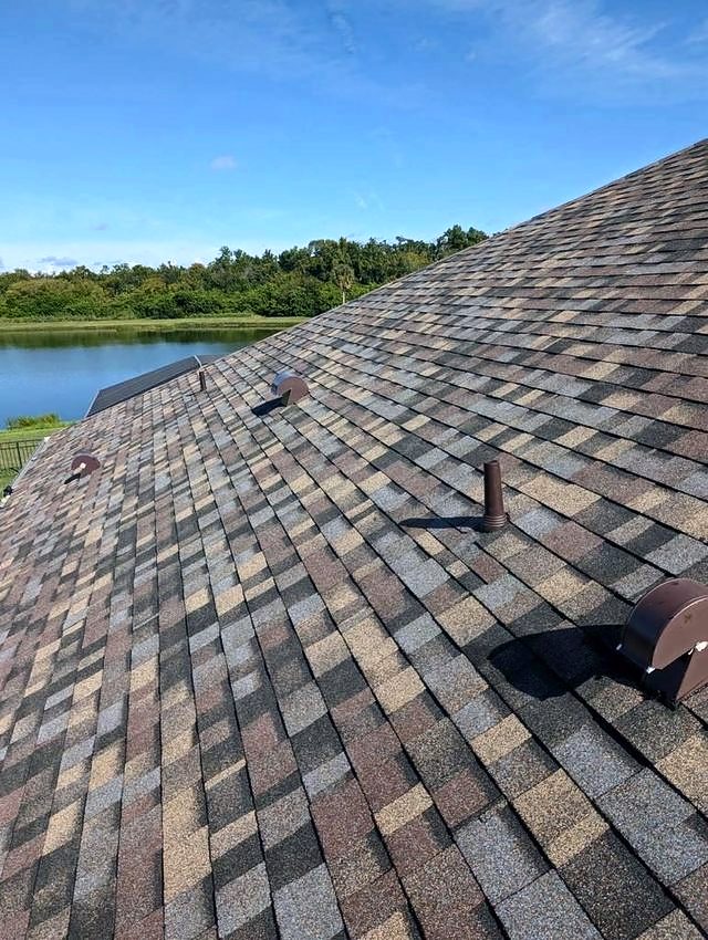 Multi-tone brown and red shingle roof with a lake beyond