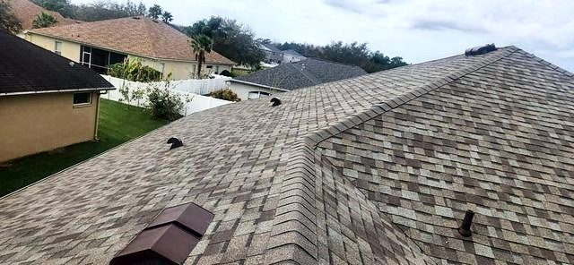 Driftwood brown shingle roof hip with neighboring homes beyond