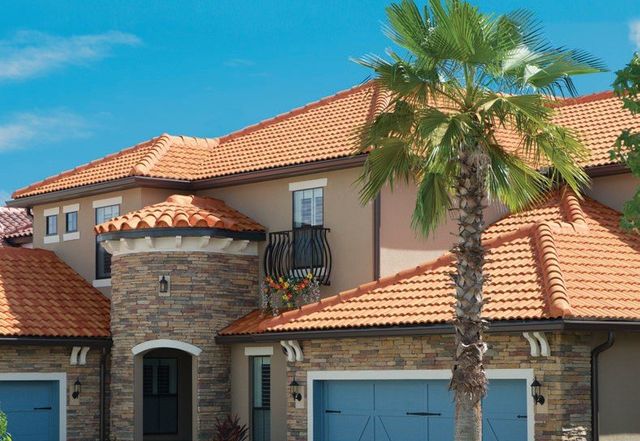 Two-story stone and stucco home with an orange barrel concrete tile roof and palm tree