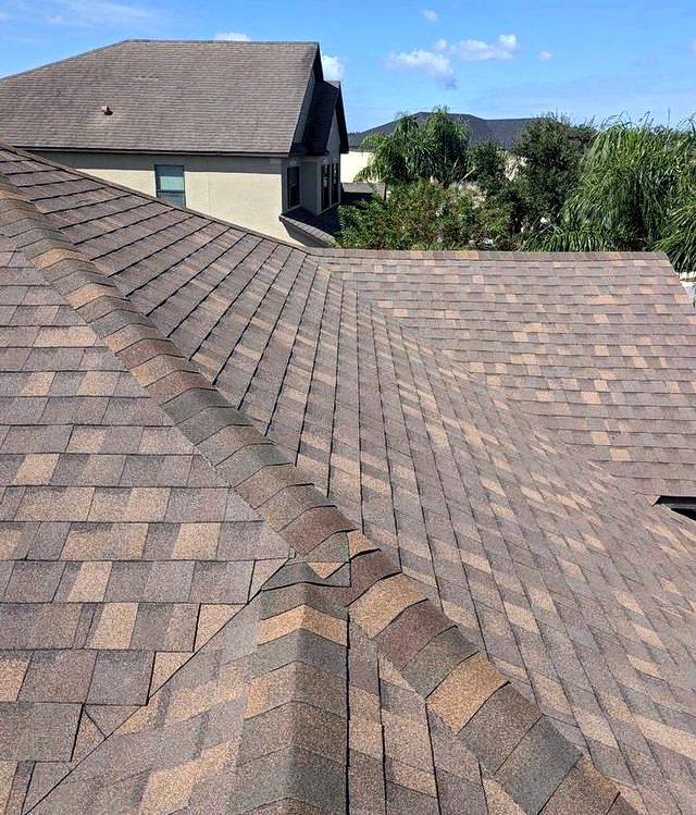 Coral-brown shingle roof ridge above a two-story home