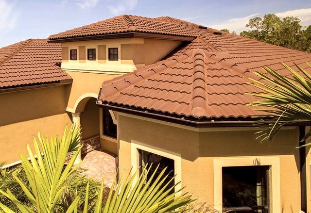 Close aerial of a terracotta concrete tile roof on a stucco home